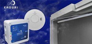 Het Enduri Power Relais afgebeeld bij een rookmelder en een deuropener met blauwe achtergrond