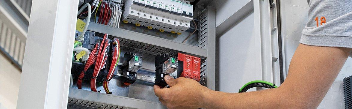 Installateur die bezig is met de industriële oplossingen van Schneider Electric in de groepenkast