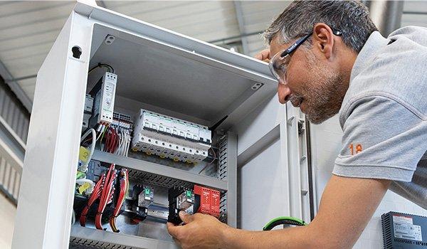 Installateur bezig in de groepenkast met de industriële oplossingen van Schneider Electric