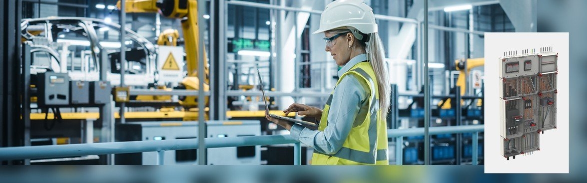 Vrouwelijke medewerker werkzaam in een autofabriek; bedrijf maakt gebruik van de ABB VMS installatiekast 
