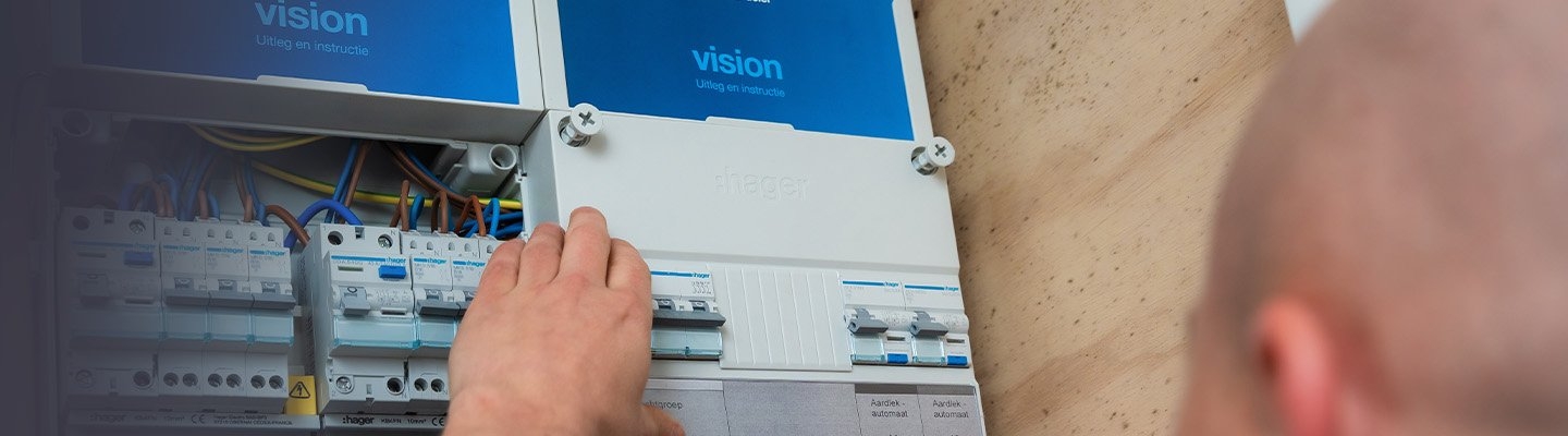 Man die een bij een Hager Vision groepenkast staat. 