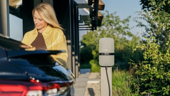 Een vrouw die haar auto laad met een Peblar laadstation